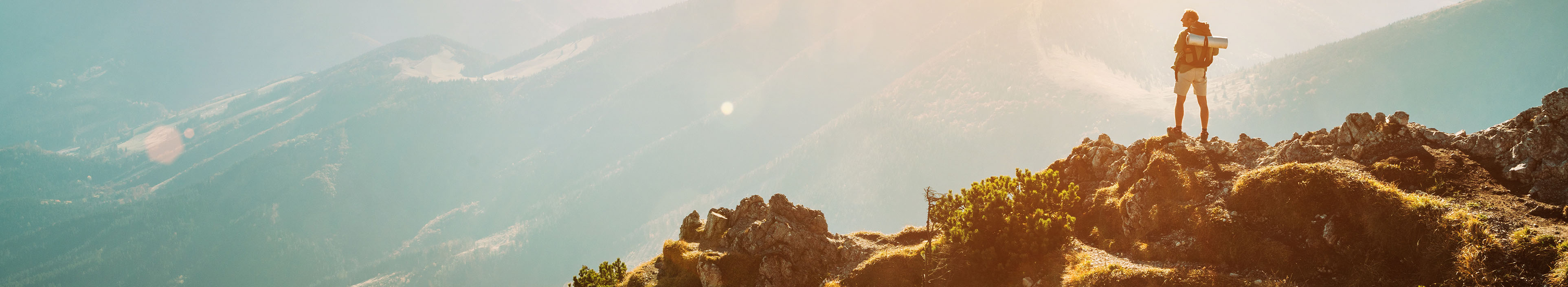 Bergwanderer mit Rucksack, auf dem Berggipfel mit wunderschönem Panorama