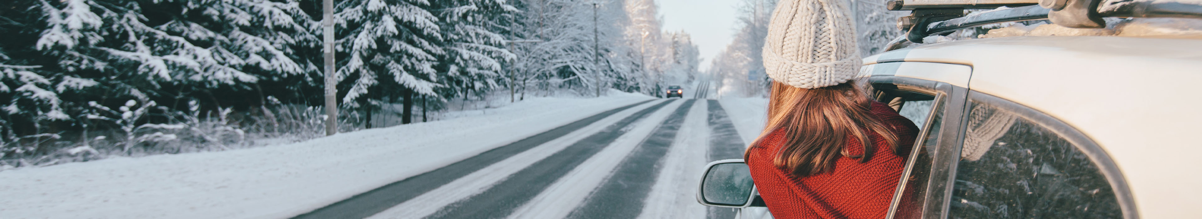 Autofahrt auf der Straße durch den schneebedeckten Winterwald