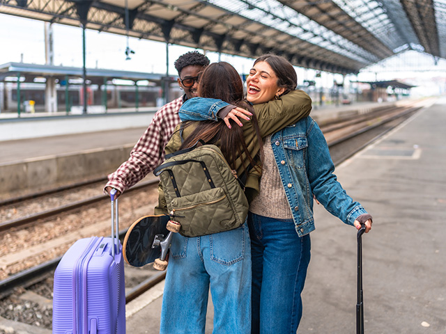 Freunde begrüßen sich am Bahnsteig.