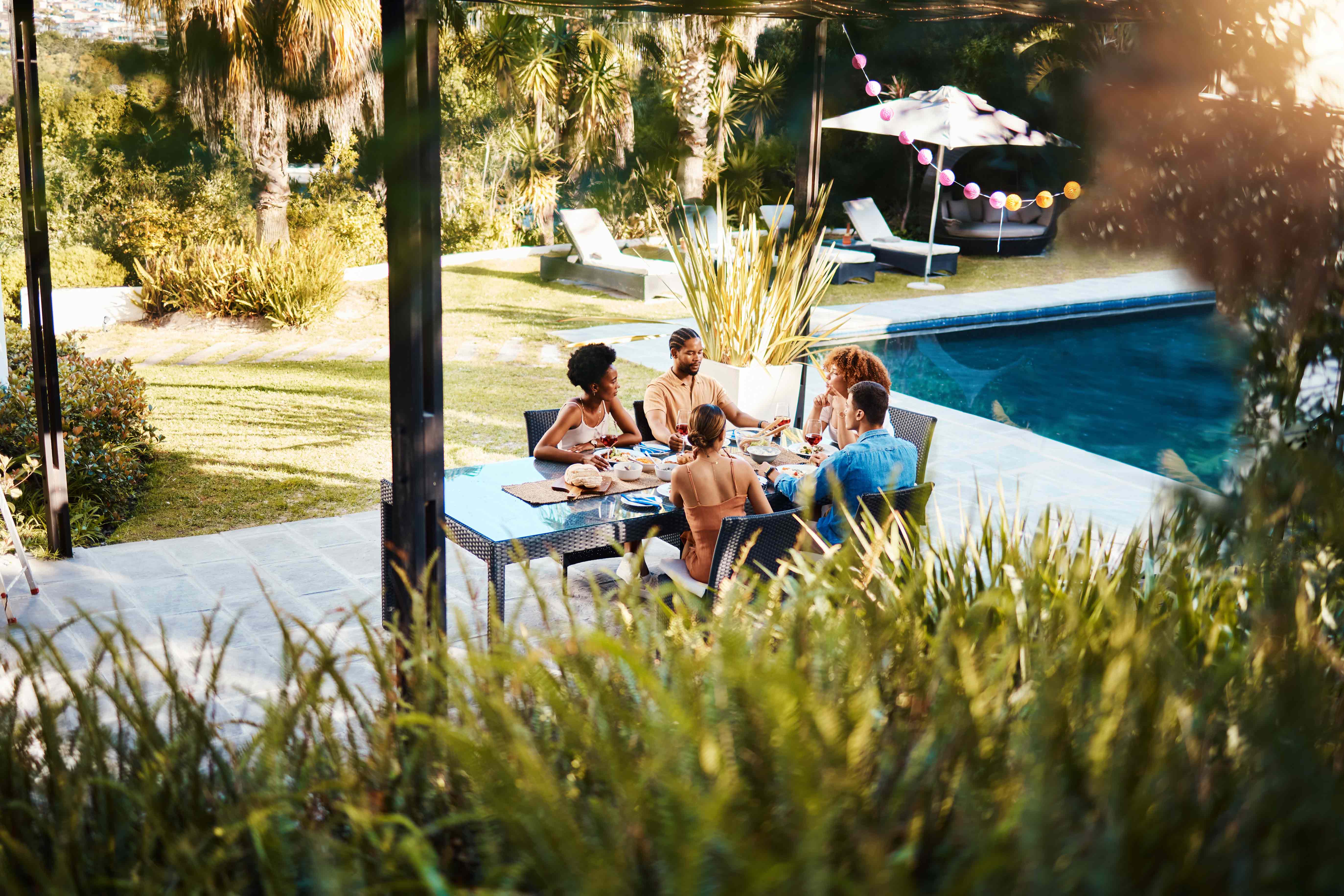 Eine Familie isst auf der Terrasse eines Ferienhauses.