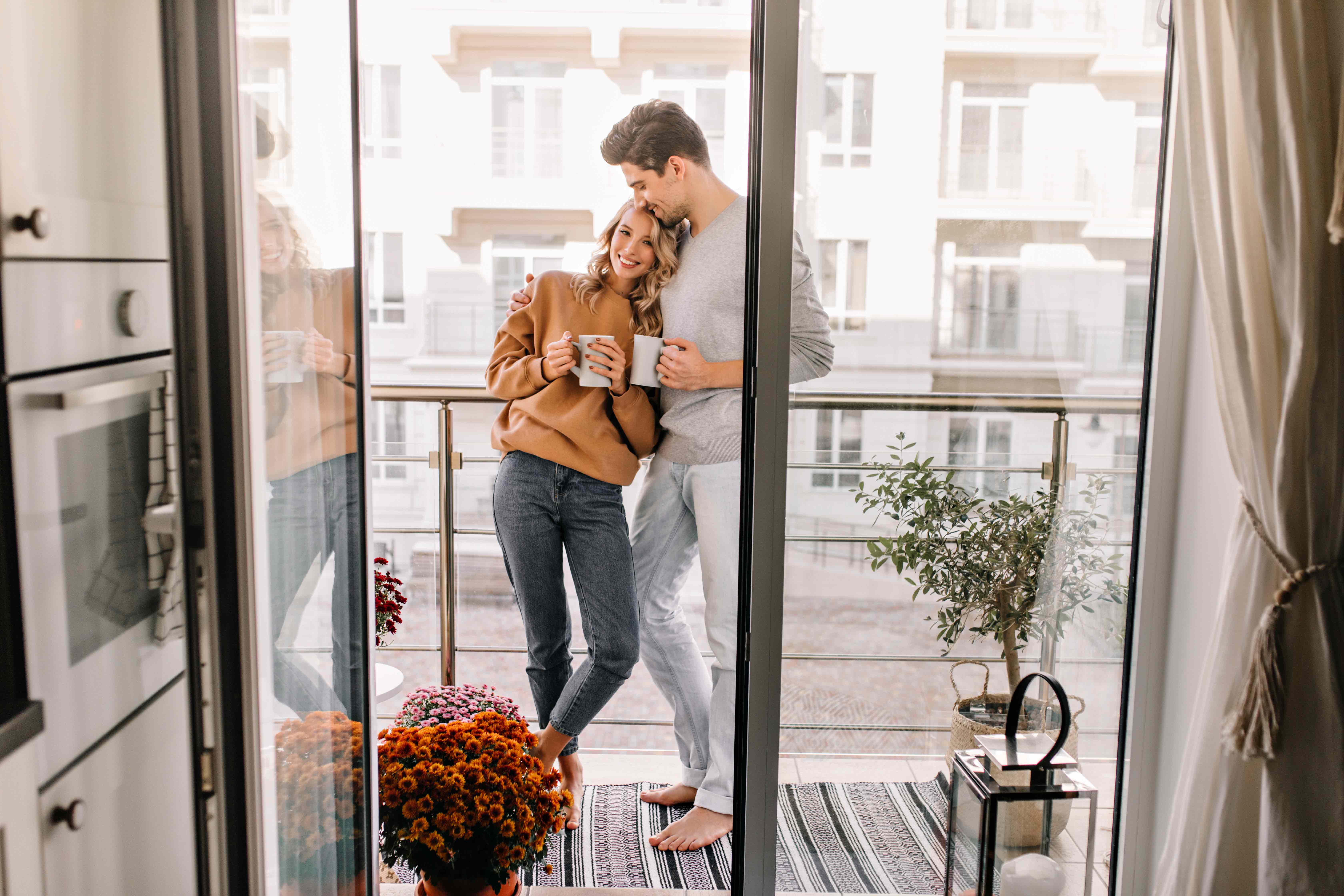 Ein Paar steht auf dem Balkon einer Ferienwohnung.