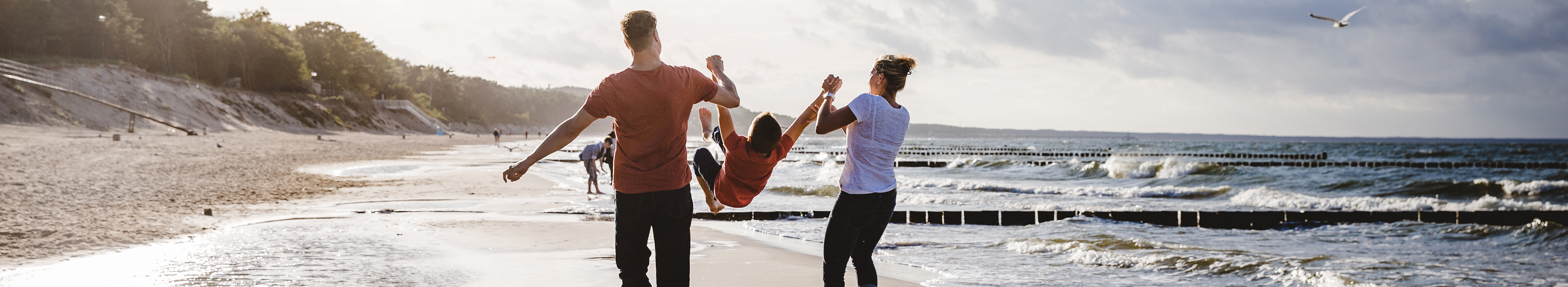 Familie glücklich am Strand an der Ostsee während eines Deutschland Urlaubs mit Lidl Reisen