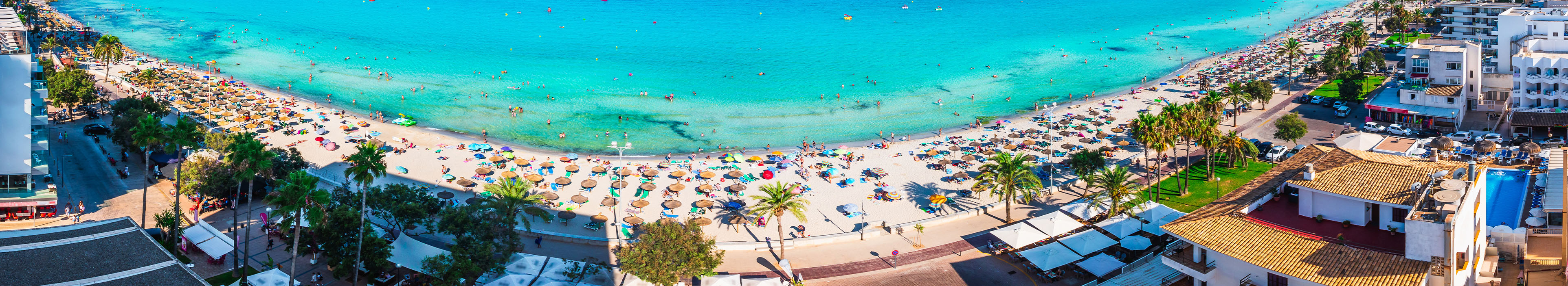 Strand in Spanien mit Hotels, Palmen, türkisblaues Meer mit Badegästen