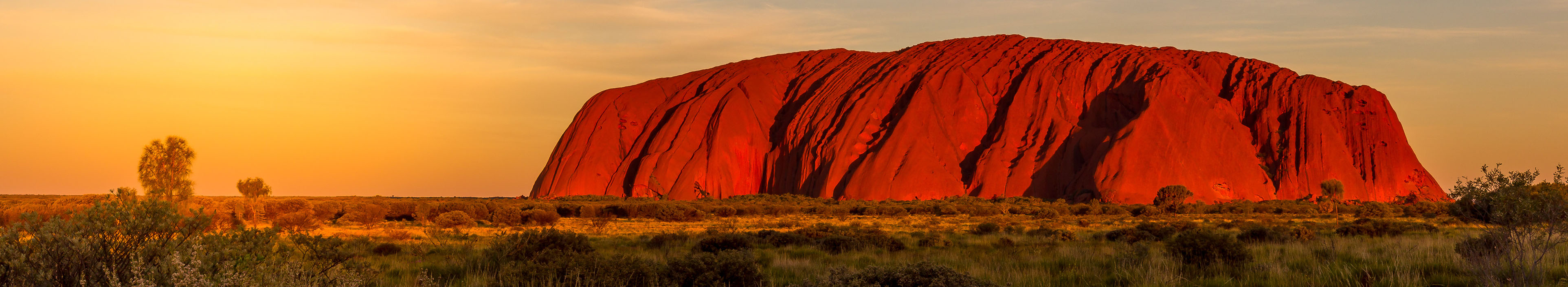 Inselberg Uluru/ Ayers Rock in der australischen Wüste, in der Dämmerung.