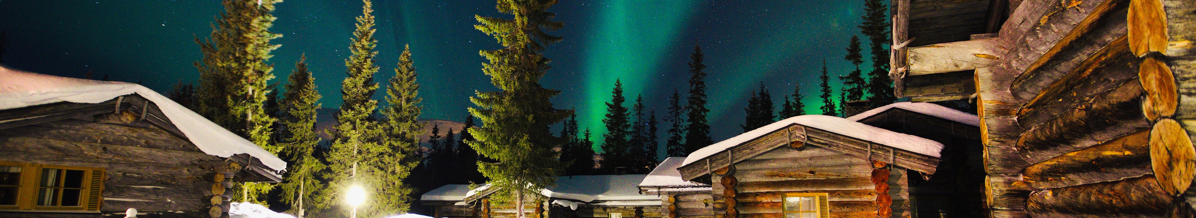 Schöne Aurora Borealis in Lappland mit sehr schönen Hütten. 