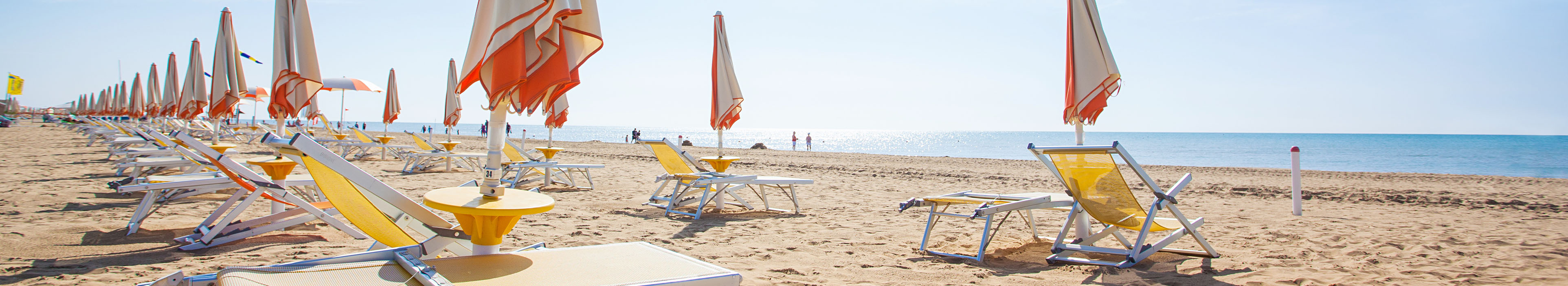 Sonnenschirme und Liegen am Strand von Bibione, Italien.