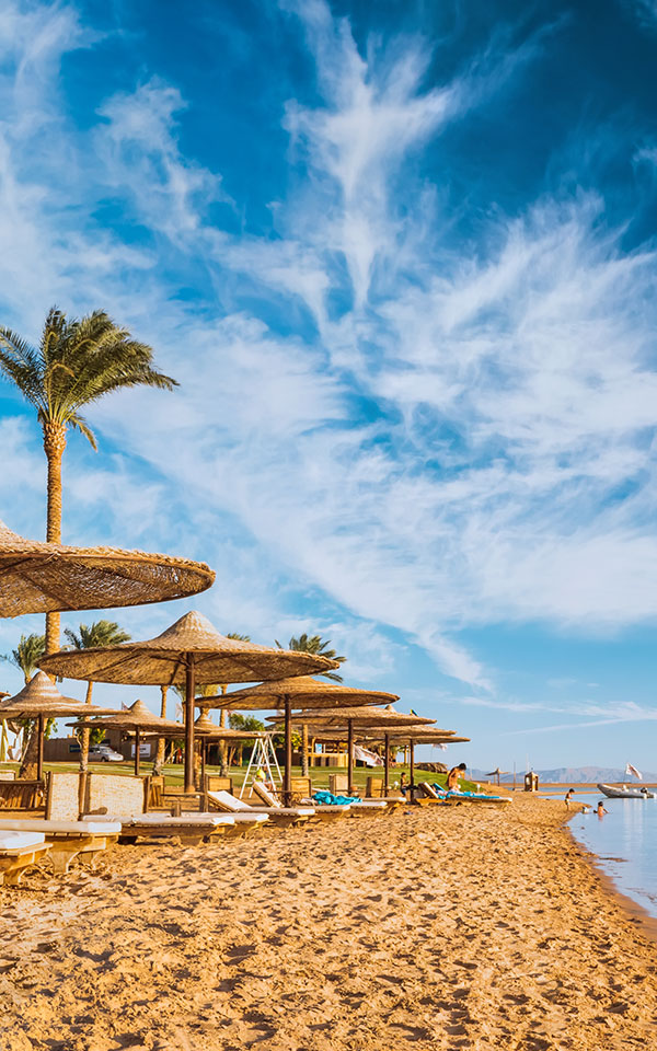 Ägypten Urlaub. Liegen mit Sonnenschirme am Strand