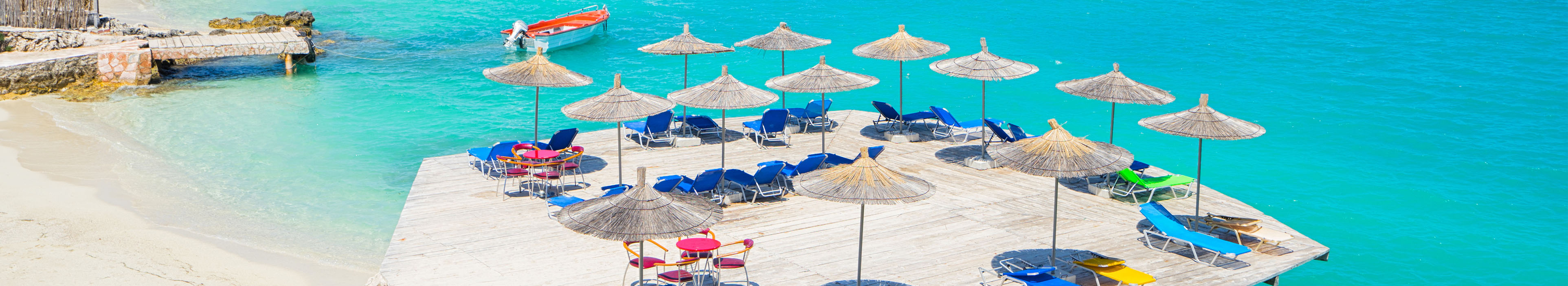 Sonnenliegen und Schirme am Ksamil Strand, mit Blick auf das Meer, Albanien.