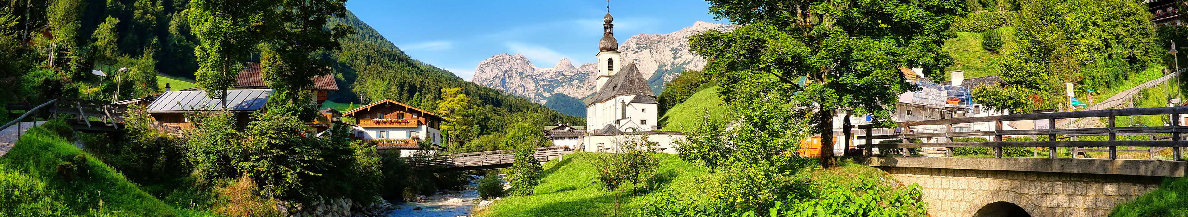 Blick auf eine Kirche, die Berge und die Landschaft in Ramsau während eines Urlaubs in Berchtesgaden