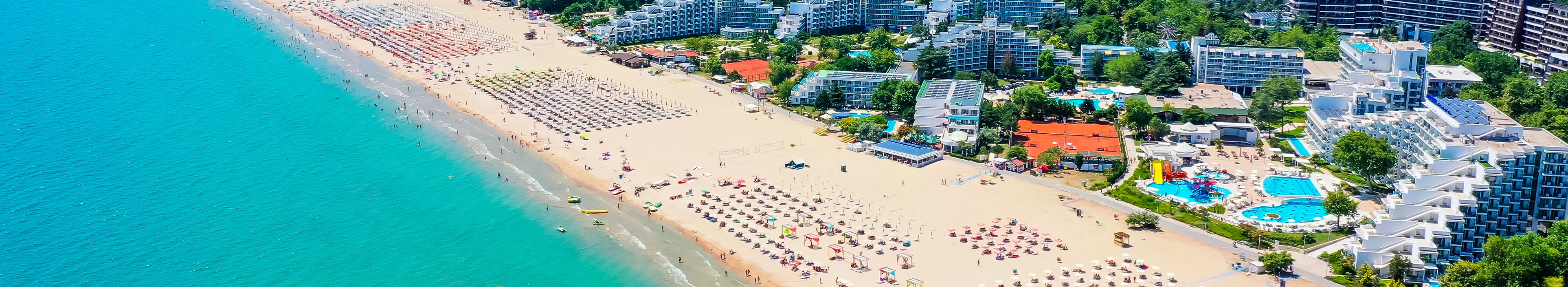 Blick auf einen Strand in Bulgarien mit Hotels und Sonnenschirmen am Strand. 