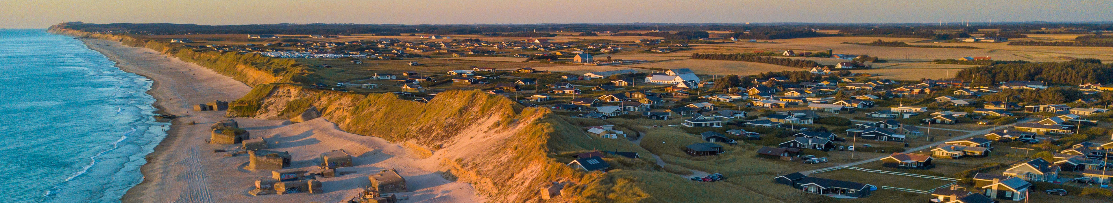 Blick auf einen Strand in Dänemark, Häuser und Küste.