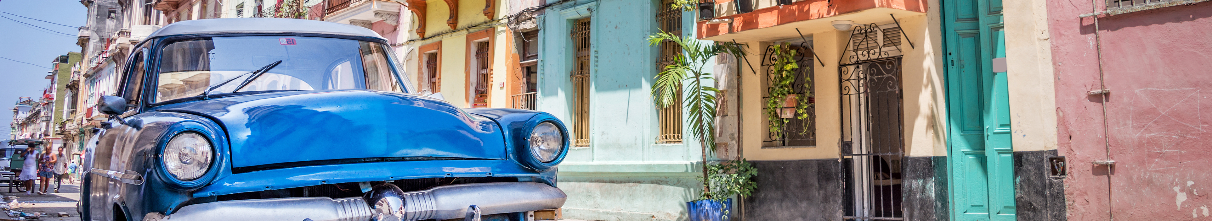 Klassisches amerikanischer blauer Oldtimer in einer farbenfrohen Straße von Havanna, Kuba