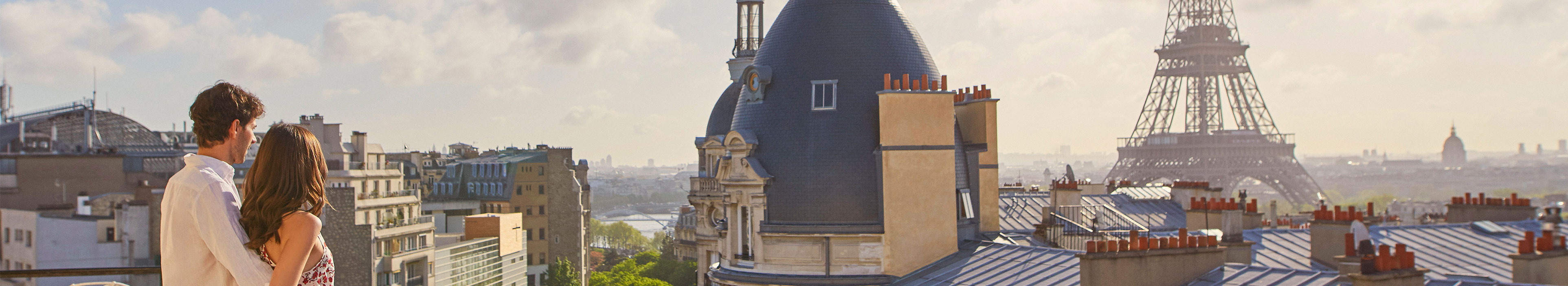 Ein Paar schaut in einem Hotel auf den Eiffelturm in Paris. 