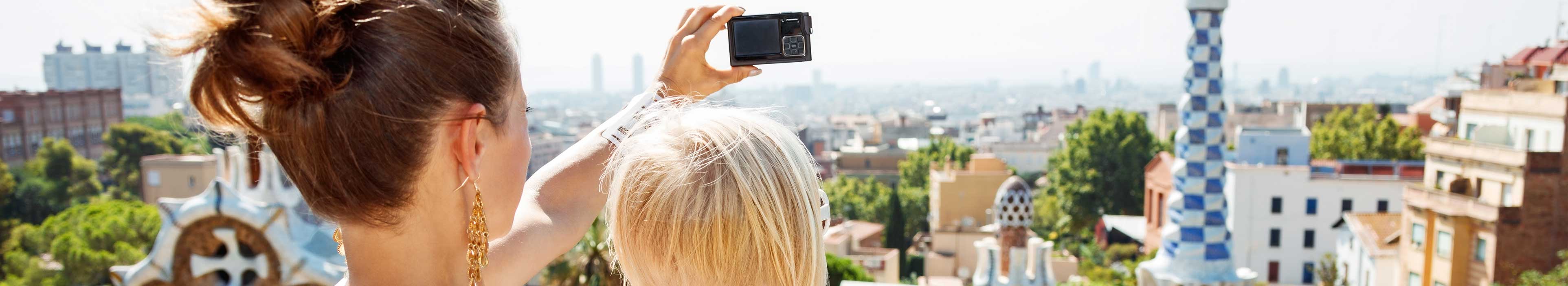 Mutter und Kind beim Fotografieren im Park Guell in Barcelona. 