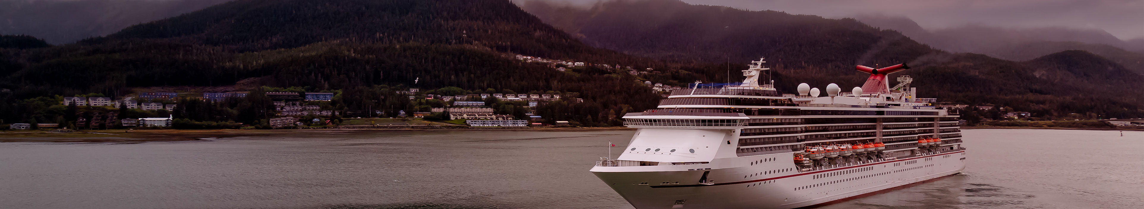 Kreuzfahrtschiff in einer kleinen touristischen Stadt. Dramatischer farbenfroher Sonnenaufgang Himmel. Juneau, Alaska, Vereinigte Staaten von Amerika.