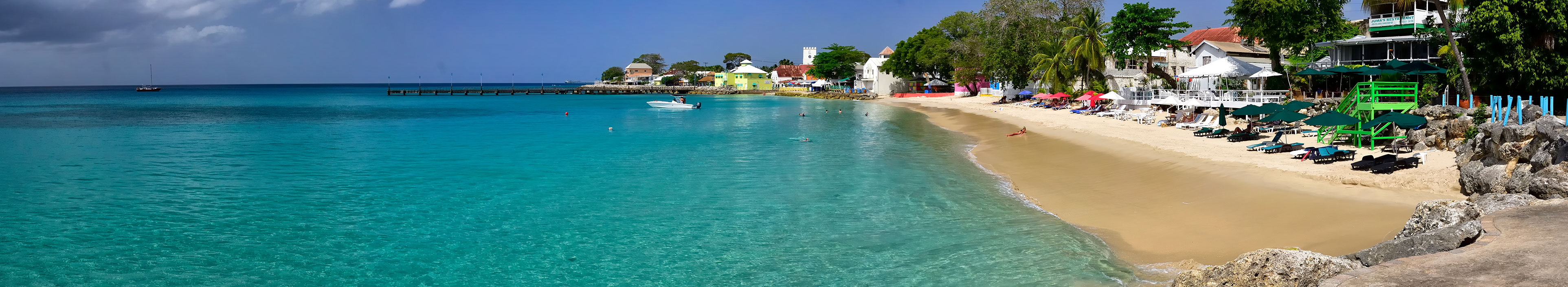 Menschen schwimmen im Meer in Speightstown, einer der größten Städte an der Westküste der Insel Barbados.