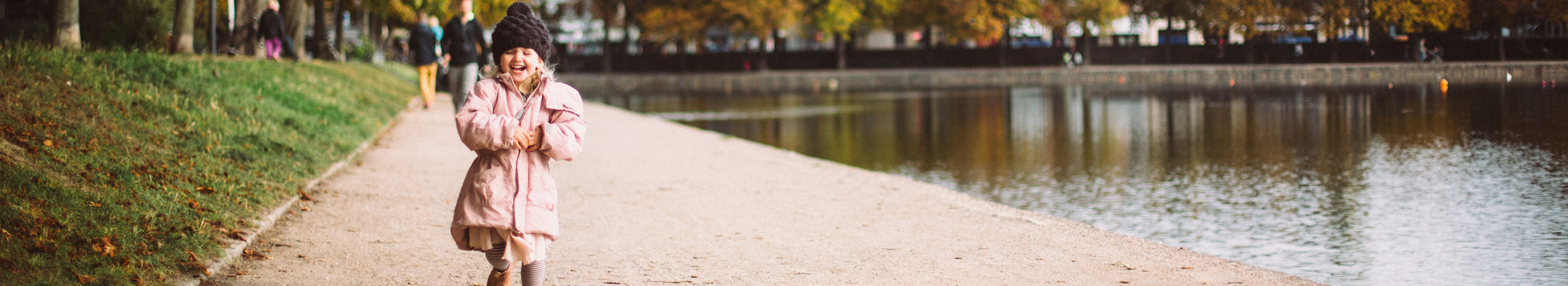 Mädchen, das an einem schönen Herbsttag am Ufer der Seen in Oesterbro Kopenhagen läuft