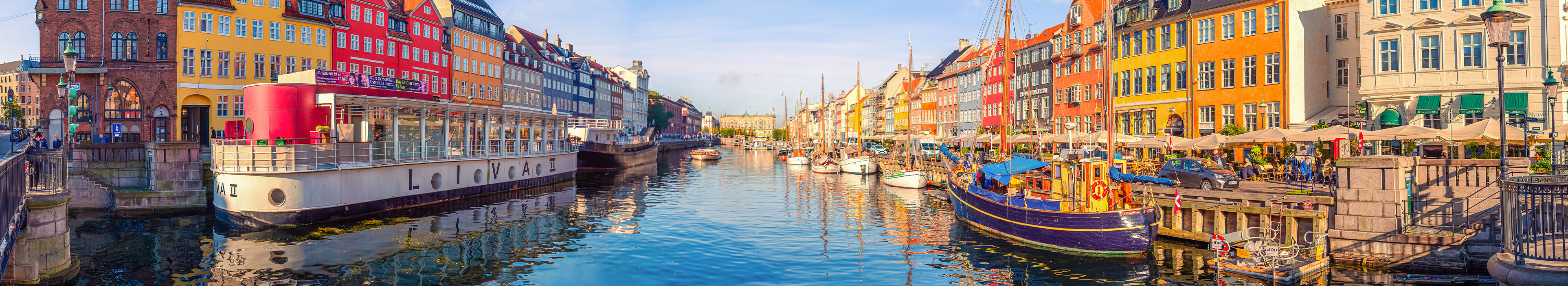 Nyhavn in Kopenhagen, bunte Häuser, ein Kanal und Schiffe