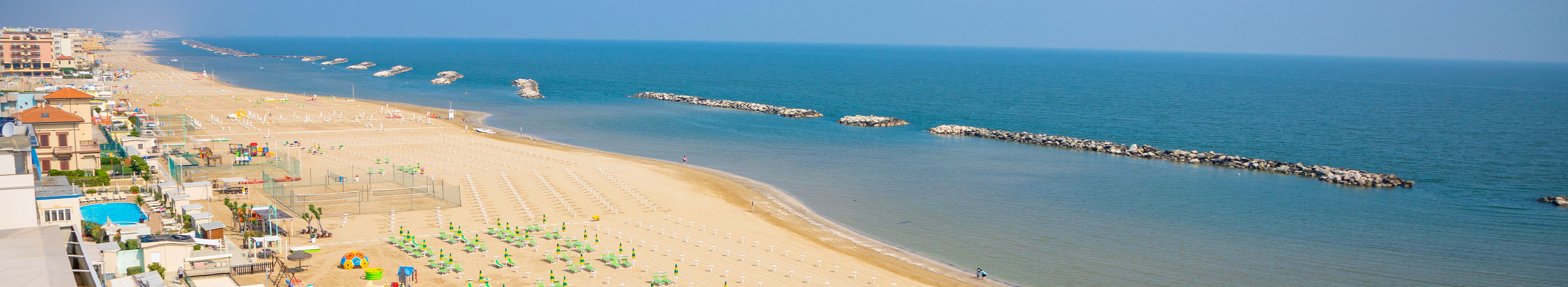 Strand in Rimini, Sonnenschirme, Liegen und Hotels.