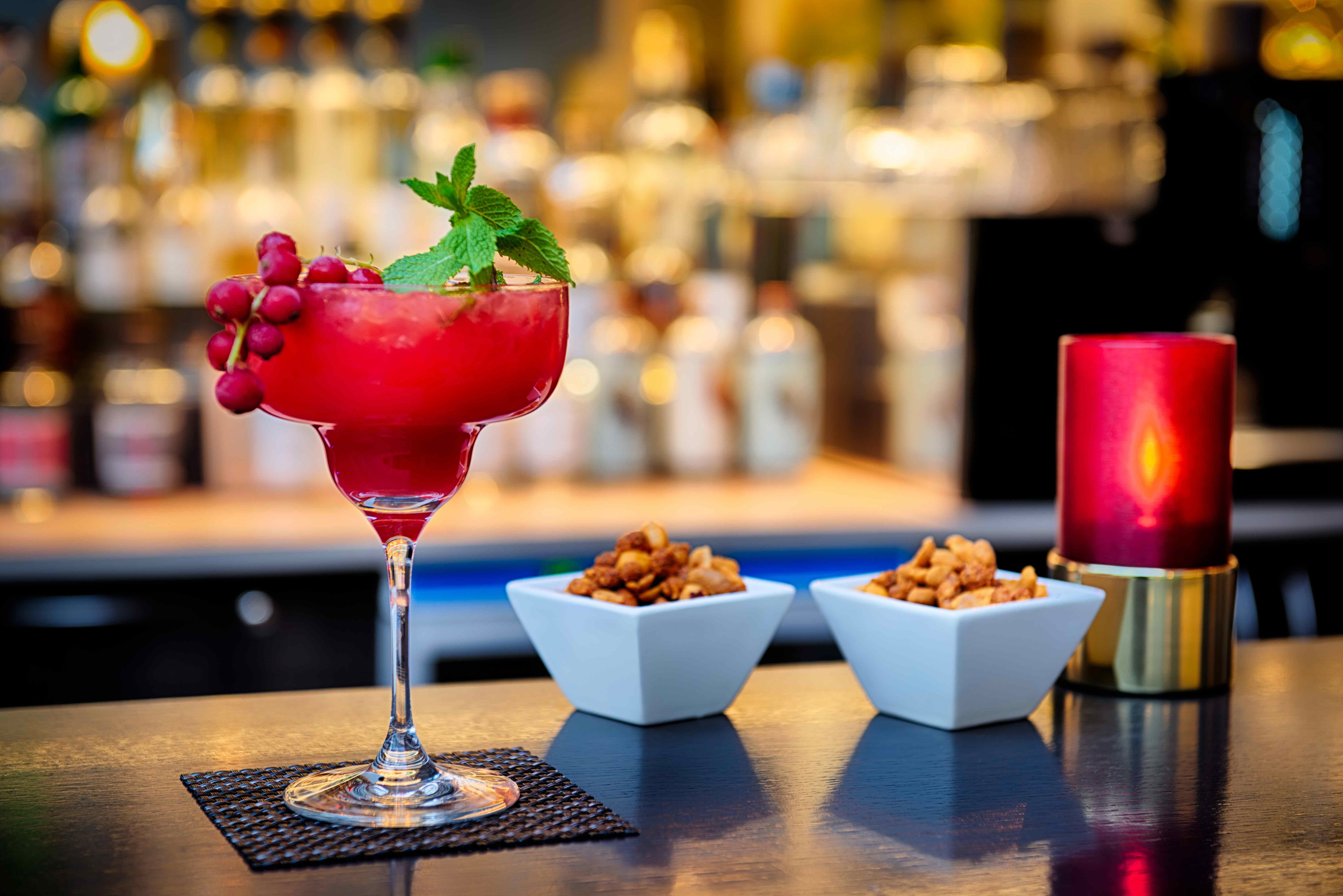 Ein pinker Drink mit Knabberzeug an der Bar im ACHAT Hotel.