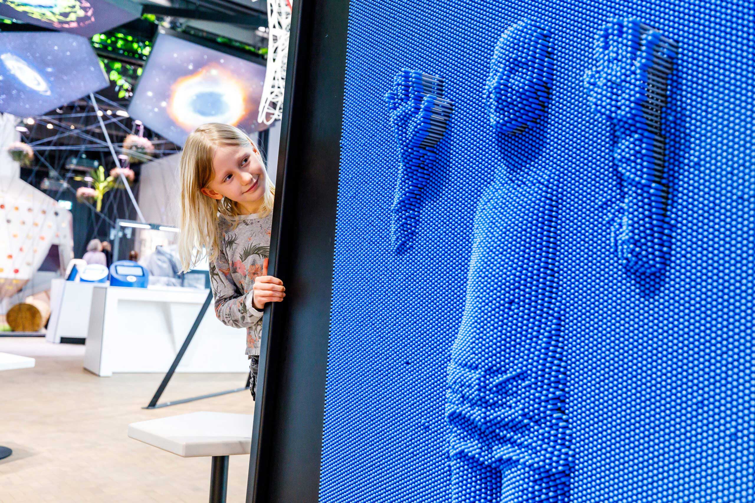 Eine Besucherin der experimenta sieht sich ihre Umrisse in einem Pinart an.